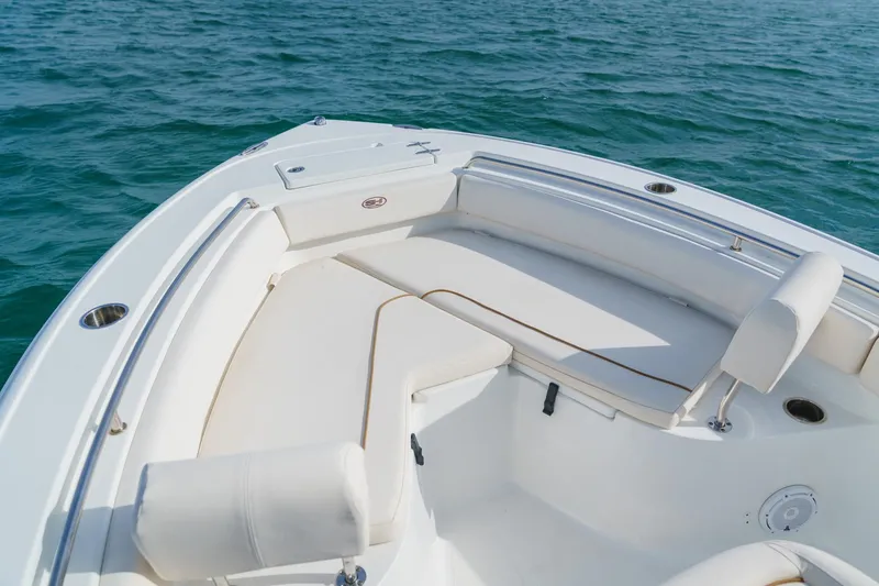 Slide: The Image of 2022 Sea Hunt Ultra 219 boat interior with cushioned seating on calm water. - 10