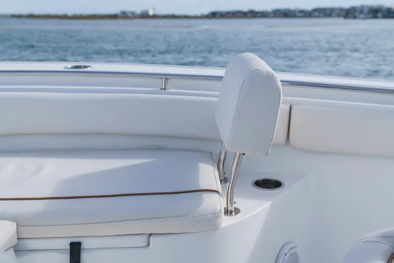 Slide: The Image of 2022 Sea Hunt Ultra 219 boat interior with white seating and ocean view. - 12