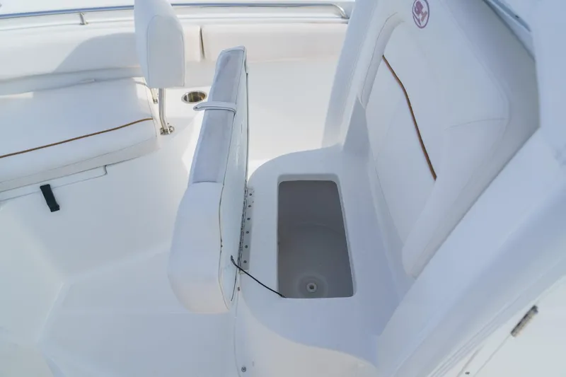 Slide: The Image of 2022 Sea Hunt Ultra 219 boat interior with white seating and storage compartment. - 13