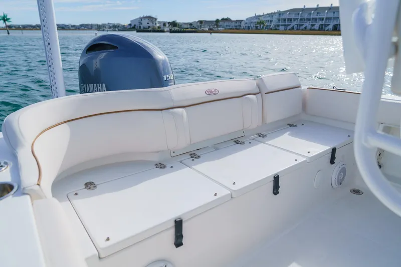 Slide: The Image of 2022 Sea Hunt Ultra 219 boat interior with Yamaha 150 engine on calm water. - 14