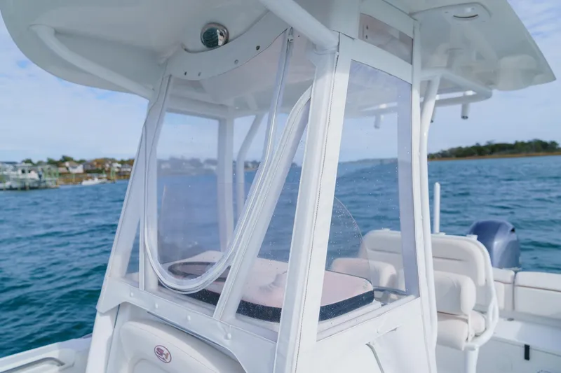 Slide: The Image of 2022 Sea Hunt Ultra 219 boat on water, featuring a clear enclosure. - 18