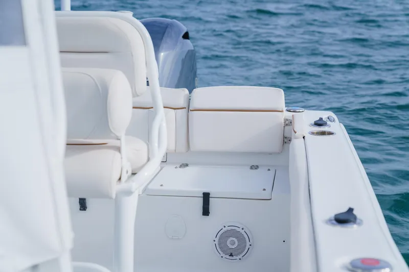 Slide: The Image of 2022 Sea Hunt Ultra 219 boat interior with white seating on blue water. - 19