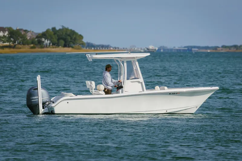 Slide: The Image of 2022 Sea Hunt Ultra 219 boat cruising on a calm blue lake. - 5