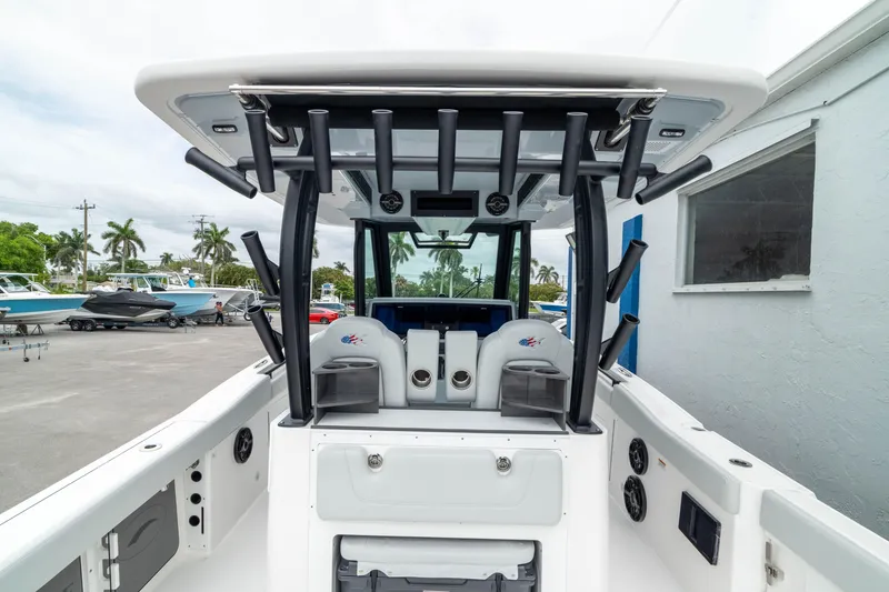 Slide: The Image of 2026 Crevalle 33 CSF boat interior with seating and rod holders, docked outdoors. - 21
