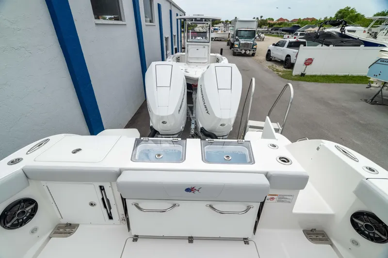 Slide: The Image of 2026 Crevalle 33 CSF boat with dual outboard engines, docked near a building. - 9