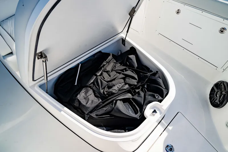 Slide: The Image of Open storage compartment on 2026 Crevalle 33 CSF boat with black fabric inside. - 12