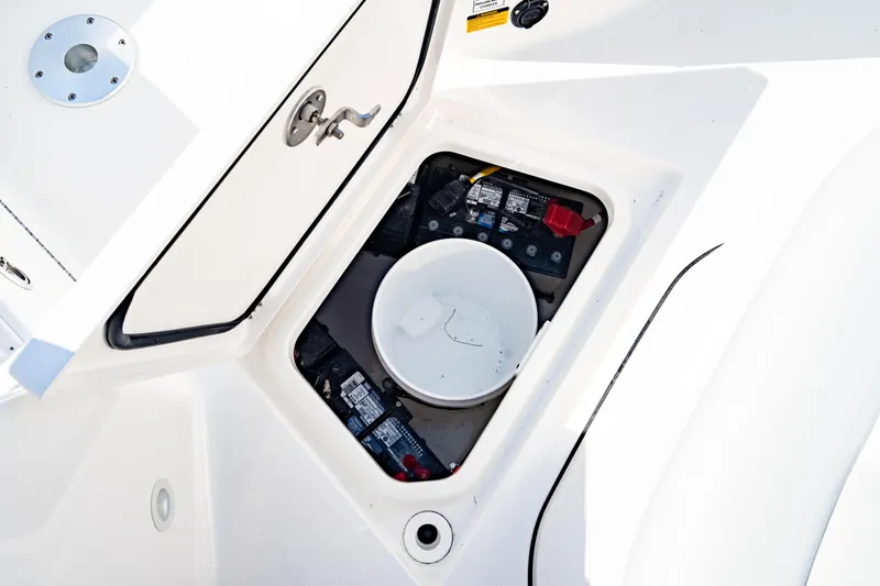 Slide: The Image of Open storage compartment on 2026 Crevalle 33 CSF boat, showing batteries and bucket. - 14