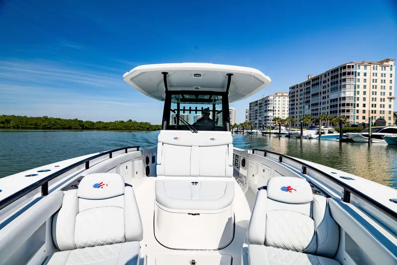 Slide: The Image of 2026 Crevalle 33 CSF boat on calm water near modern waterfront buildings. - 3