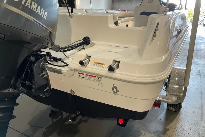 Slide: The Image of 2023 Hurricane SunDeck Sport 201 OB boat with outboard motor, parked outdoors. - 10