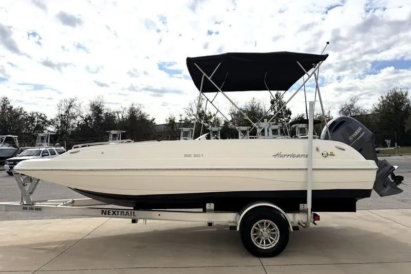 Slide: The Image of 2023 Hurricane SunDeck Sport 201 OB boat on trailer, featuring a black canopy. - 32