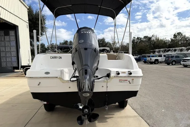 Slide: The Image of 2023 Hurricane SunDeck Sport 201 OB boat with outboard motor, parked outdoors. - 38