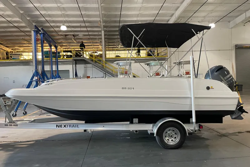 Slide: The Image of 2023 Hurricane SunDeck Sport 201 OB boat on trailer, featuring a black canopy. - 4