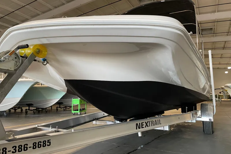 Slide: The Image of 2023 Hurricane SunDeck Sport 201 OB boat on trailer under cloudy sky. - 9