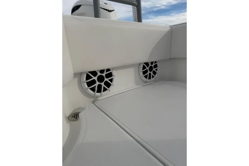Slide: The Image of 2024 SeaHunter 28 Floridian boat interior with speakers and cushioned seating. - 27