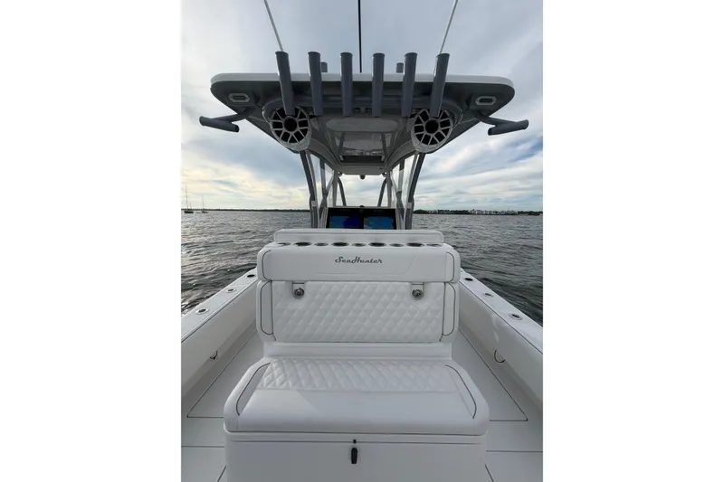 Slide: The Image of 2024 SeaHunter 28 Floridian boat interior with seating and rod holders on open water. - 28