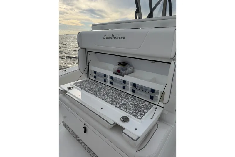 Slide: The Image of 2024 SeaHunter 28 Floridian boat with open storage compartment, ocean view in background. - 29