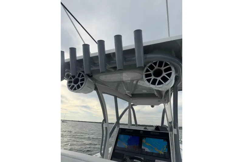 Slide: The Image of 2024 SeaHunter 28 Floridian boat console with rod holders and speakers on a calm sea. - 33