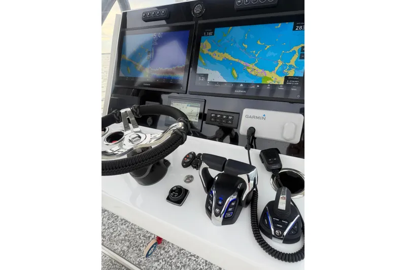 Slide: The Image of 2024 SeaHunter 28 Floridian boat dashboard with Garmin navigation displays and controls. - 38