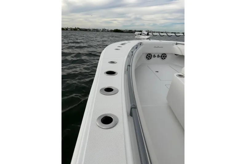 Slide: The Image of 2024 SeaHunter 28 Floridian boat deck with rod holders, on calm water. - 44