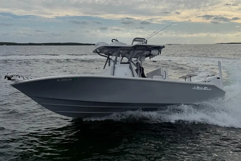 Slide: The Image of 2024 SeaHunter 28 Floridian boat cruising on open water at sunset. - 8