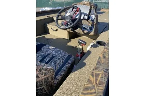 Slide: The Image of 2026 G3 Sportsman 1810 PFX Camo boat interior with steering wheel and camo seating. - 4