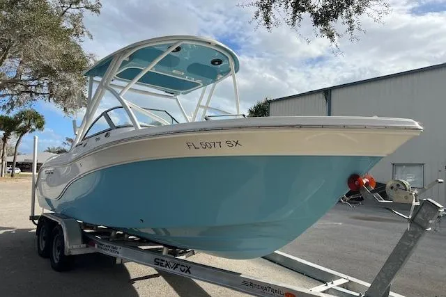 The Image of 2021 Sea Fox 226 Traveler boat on trailer, light blue hull, parked outdoors. - 0