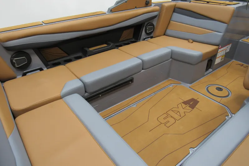 Slide: The Image of 2026 Axis A225 boat interior with tan and gray seating, featuring "Axis" branding on the floor. - 5