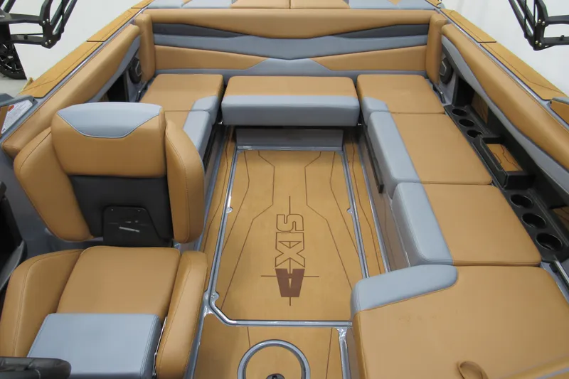 Slide: The Image of 2026 Axis A225 boat interior with tan and gray seating, featuring ample storage and cup holders. - 9
