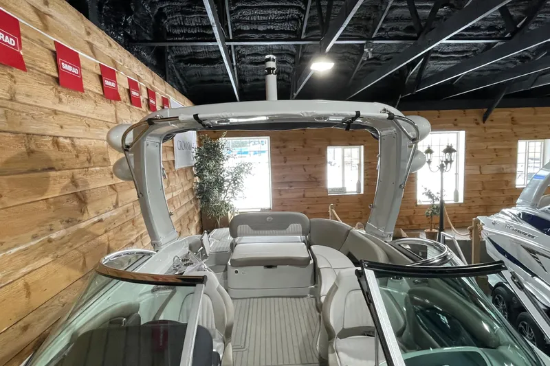 Slide: The Image of 2026 Crownline 298 SS boat displayed indoors with wooden walls and modern design. - 12