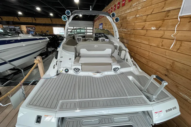 Slide: The Image of 2026 Crownline 298 SS boat interior with seating and speakers in a showroom. - 4
