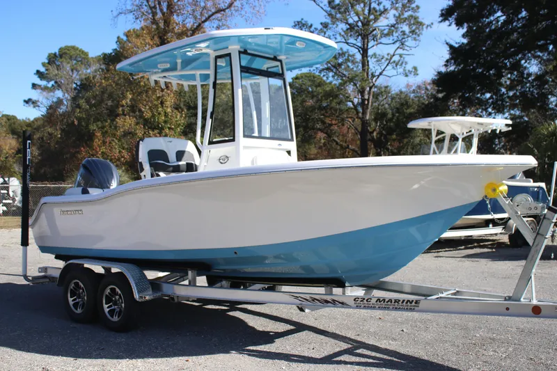 Slide: The Image of 2026 Tidewater 210 LXF boat on trailer, white and blue design, parked outdoors. - 10