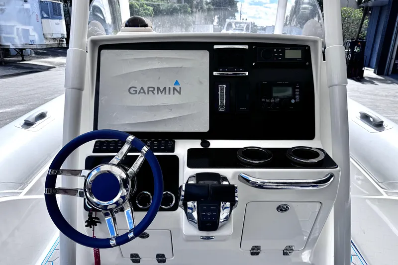 Slide: The Image of Control panel of 2014 Airship 330 boat featuring Garmin navigation system and steering wheel. - 10