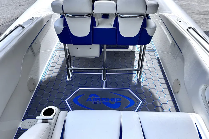 Slide: The Image of Interior of 2014 Airship 330 boat with blue and white seating and hexagonal floor design. - 8