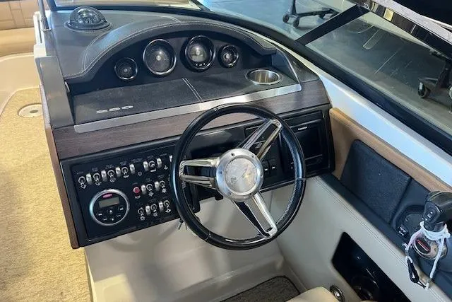 Slide: The Image of Interior dashboard of 2016 Sea Ray 250 SLX boat with steering wheel and control panel. - 16