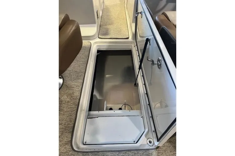 Slide: The Image of Open storage compartment on 2016 Sea Ray 250 SLX boat, featuring carpeted flooring. - 25
