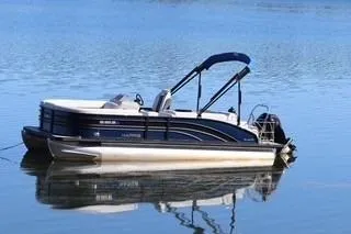 The Image of 2021 Harris FloteBote Sunliner 230 pontoon boat on calm water. - 0