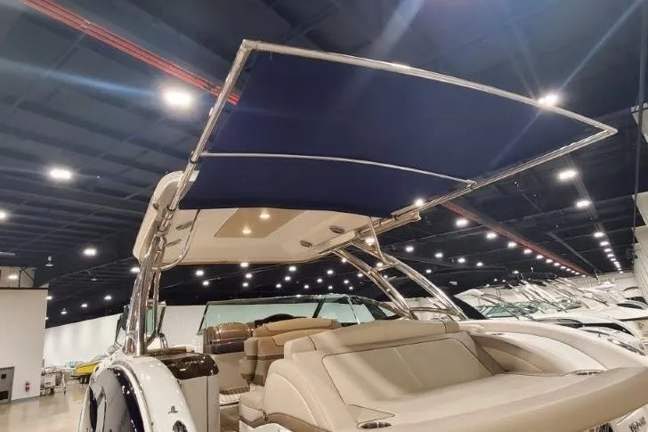 Slide: The Image of 2017 Formula 350 Crossover Bowrider with blue canopy in showroom setting. - 62