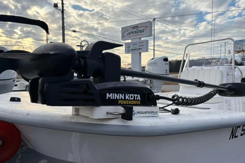 Slide: The Image of 2024 Coastal Skiff 171 with Minn Kota PowerDrive motor, under a cloudy sky. - 5