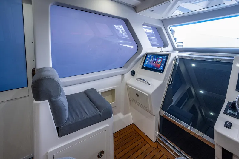 Slide: The Image of Interior helm station of 2021 Gulf Crosser 52 yacht with touchscreen display and cushioned seat. - 10
