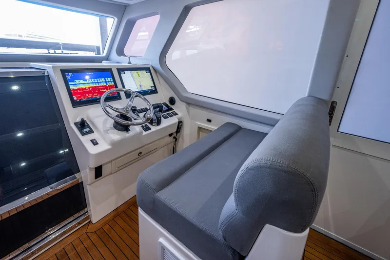Slide: The Image of 2021 Gulf Crosser 52 helm station with modern navigation displays and comfortable seating. - 11