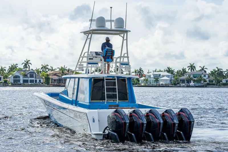 Slide: The Image of 2021 Gulf Crosser 52 boat with quad outboard engines cruising on water. - 2