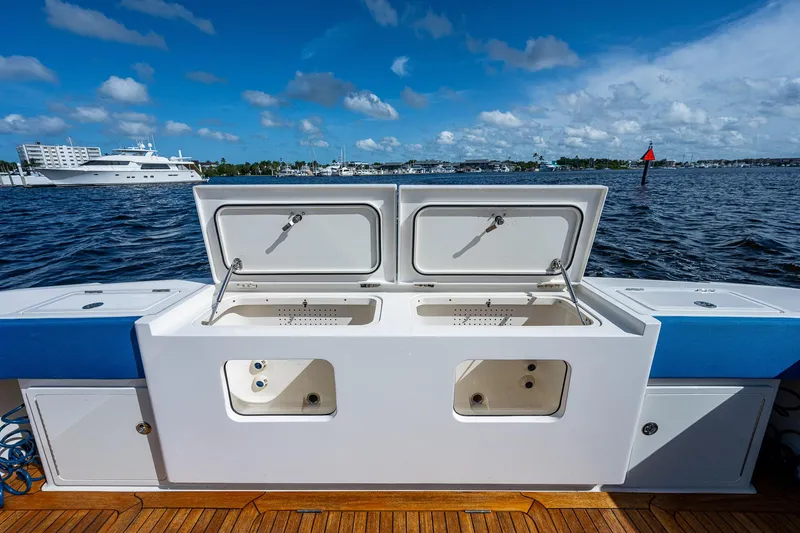 Slide: The Image of 2021 Gulf Crosser 52 boat with open storage compartments on deck, docked by the water. - 22