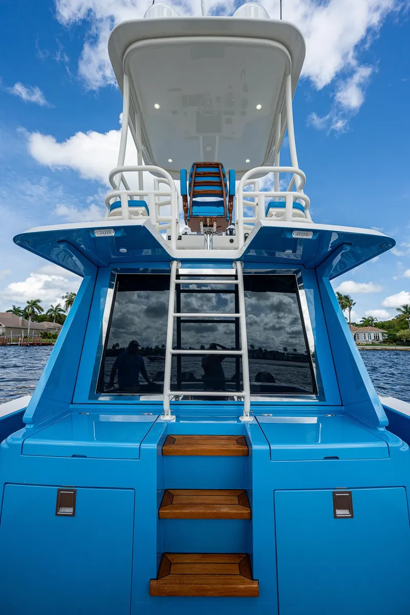 Slide: The Image of 2021 Gulf Crosser 52 yacht with blue exterior and ladder, docked on a sunny day. - 28