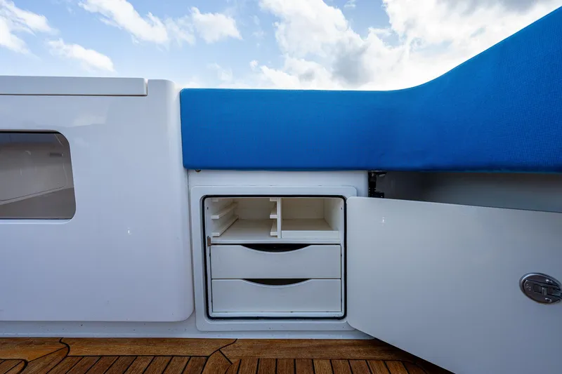 Slide: The Image of Storage compartment on a 2021 Gulf Crosser 52 yacht with blue cushion seating. - 32