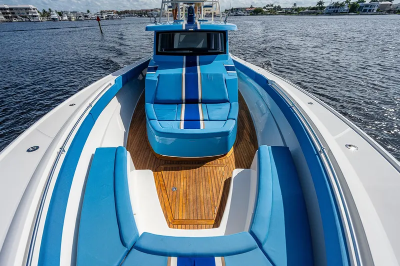 Slide: The Image of 2021 Gulf Crosser 52 boat with blue and white seating on the water. - 38