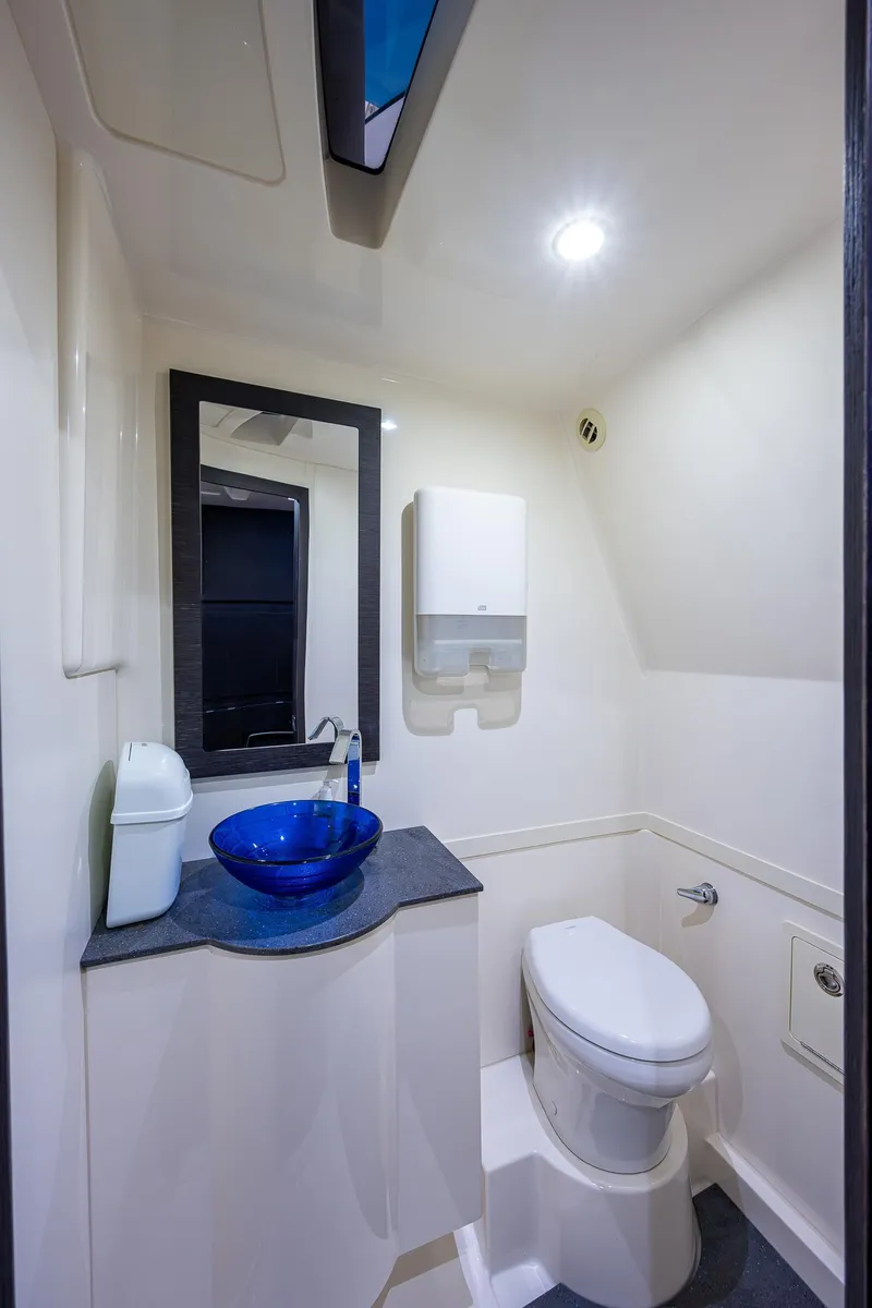 Slide: The Image of Modern bathroom in 2021 Gulf Crosser 52 yacht with blue glass sink and white fixtures. - 46