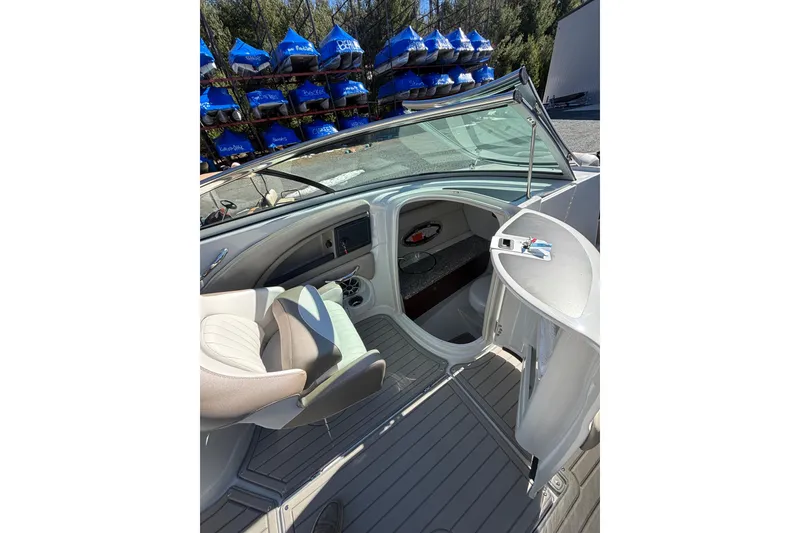 Slide: The Image of 2026 Crownline 278 SS boat interior with seating and console, docked near blue canopies. - 22