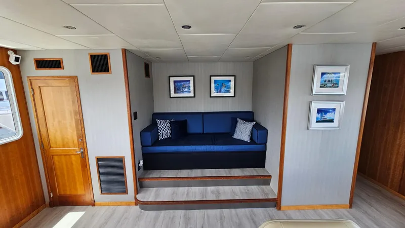 Slide: The Image of Luxurious 2009 Custom Flybridge Motoryacht interior with blue sofa and framed artwork. - 27