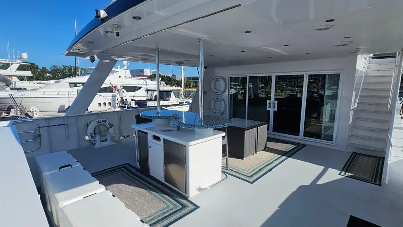 Slide: The Image of Luxurious 2009 Custom Flybridge Motoryacht deck with seating, bar, and marina view. - 48