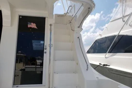 Slide: The Image of 2008 Silverton 45 Convertible yacht with stairs and American flag reflection. - 11